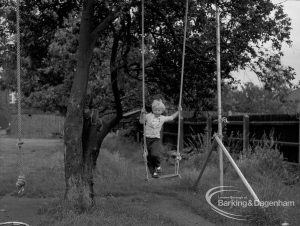 Child Welfare at Woodstock Hall House, Harold Wood, showing small boy standing on swing among trees, 1968