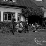 Child Welfare at Tudor House, 212 Becontree Avenue, Dagenham, showing the house and residents tidying garden and mowing grass, 1968