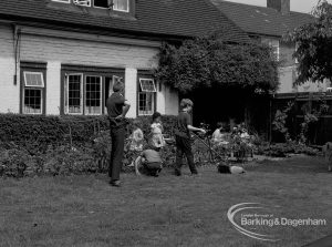 Child Welfare at Tudor House, 212 Becontree Avenue, Dagenham, showing the house and residents tidying garden and mowing grass, 1968