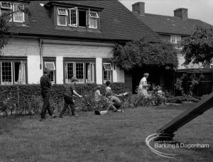Child Welfare at Tudor House, 212 Becontree Avenue, Dagenham, showing the house and residents tidying garden and mowing grass, and with part of slide on right, 1968