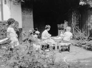 Child Welfare at Tudor House, 212 Becontree Avenue, Dagenham, showing children and tea table on patio, 1968