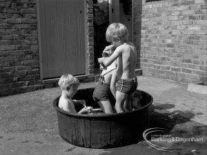 Child welfare at house at 26 – 28 Manor Road, Romford, showing three children playing in tub of water, 1968