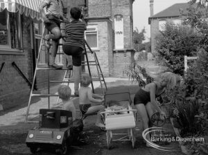 Child welfare at house at 26 – 28 Manor Road, Romford, showing boys on climbing frame and toy car, and girl mangling, 1968