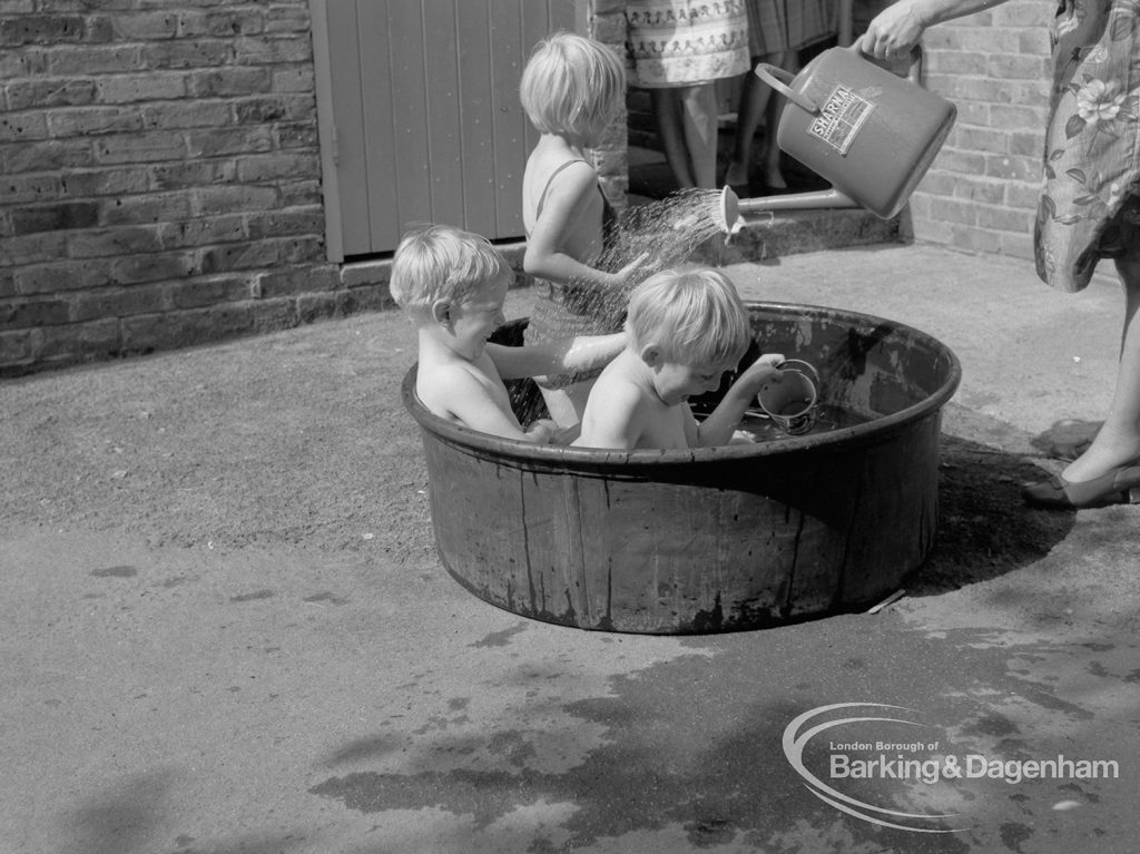 Child welfare at house at 26 – 28 Manor Road, Romford, showing three children playing in tub of water, and woman with watering can, 1968