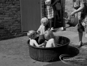 Child welfare at house at 26 – 28 Manor Road, Romford, showing three children playing in tub of water, and woman with watering can, 1968