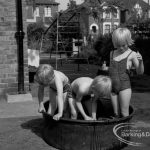 Child welfare at house at 26 – 28 Manor Road, Romford, showing three children playing in tub of water, 1968