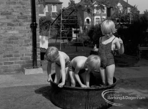 Child welfare at house at 26 – 28 Manor Road, Romford, showing three children playing in tub of water, 1968