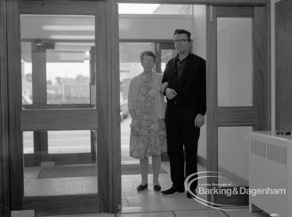 Welfare, showing Leys Avenue Occupational Centre for the Physically Handicapped, Dagenham, with patient and member of staff at entrance facing reception desk [building officially opened 15 October], 1968