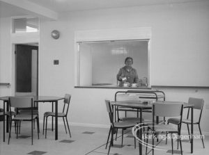 Welfare, showing Leys Avenue Occupational Centre for the Physically Handicapped, Dagenham, with the canteen with tables and chairs and a member of staff pouring tea, 1968
