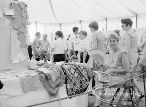 Dagenham Town Show 1969, showing Handicrafts exhibition with display of fabrics, woman with a fan, and visitors, 1969