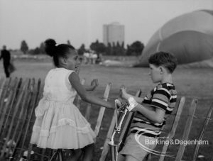Dagenham Town Show 1969, showing young boy and girl talking next to arena and hot-air balloon in background, 1969