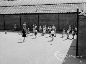 St Chad’s Infant School, Japan Road, Chadwell Heath (building ceasing to be used as school), with children and adults in corner of sun-baked playground, 1969