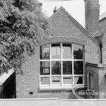 St Chad’s Infant School, Japan Road, Chadwell Heath (building ceasing to be used as school), with gable and large window of wing touching St Chad’s Park footpath, and tree on left, 1969
