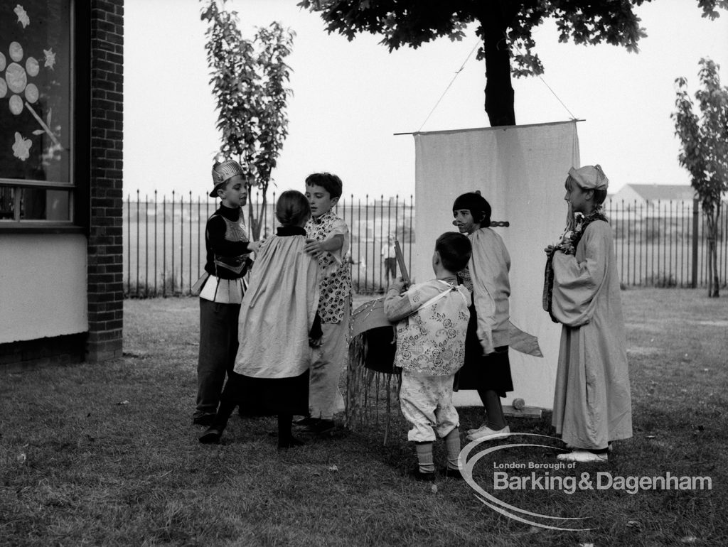 Rectory Library, Dagenham production of ‘The Price of Wisdom’ in grounds of library, produced by Mrs Jean Hickman, showing group of six players in oriental costume, with white banner, 1969