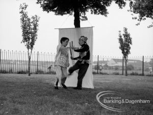 Rectory Library, Dagenham production of ‘The Price of Wisdom’ in grounds of library, produced by Mrs Jean Hickman, showing two characters standing against white screen on tree, 1969