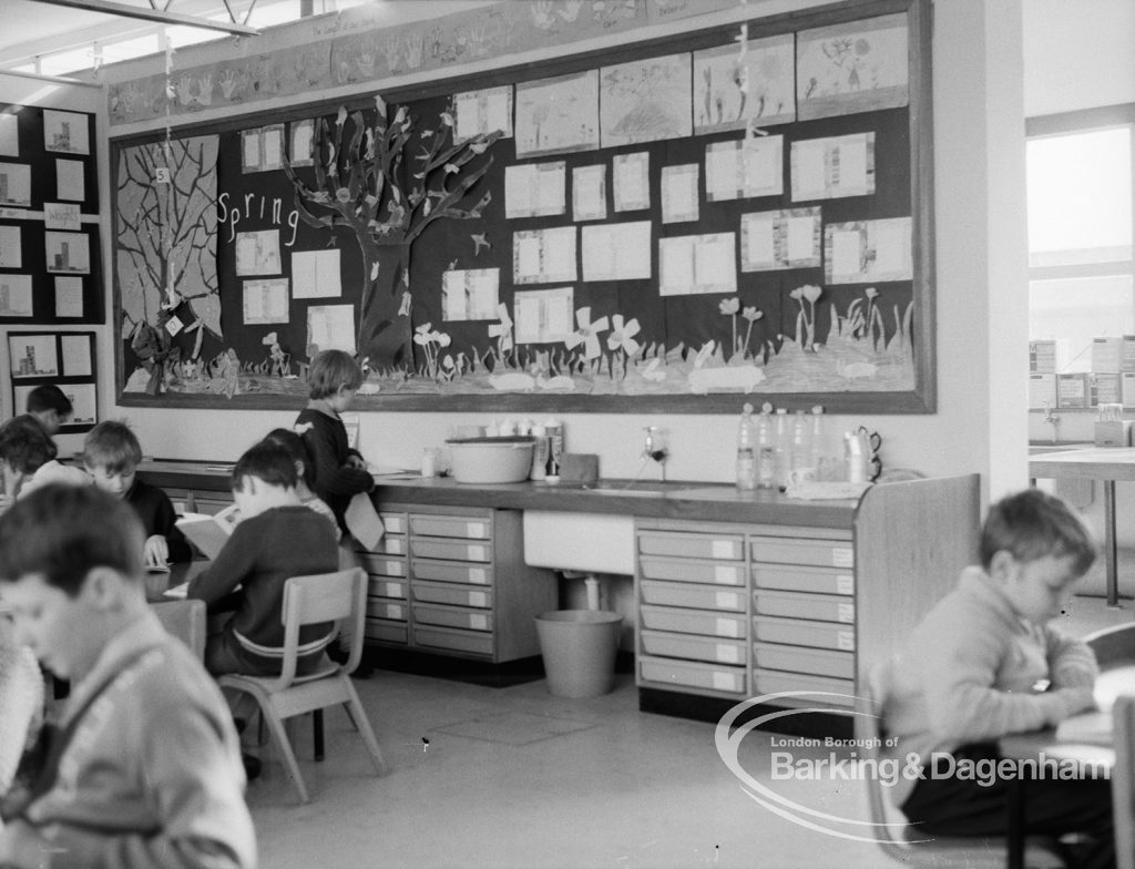 New William Bellamy Primary School, Becontree Heath, showing classroom looking north, with children seated around tables and decorated board on wall, 1970