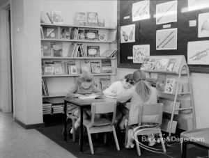 New William Bellamy Primary School, Becontree Heath, showing the library corner, with three girls seated around table and reading, 1970