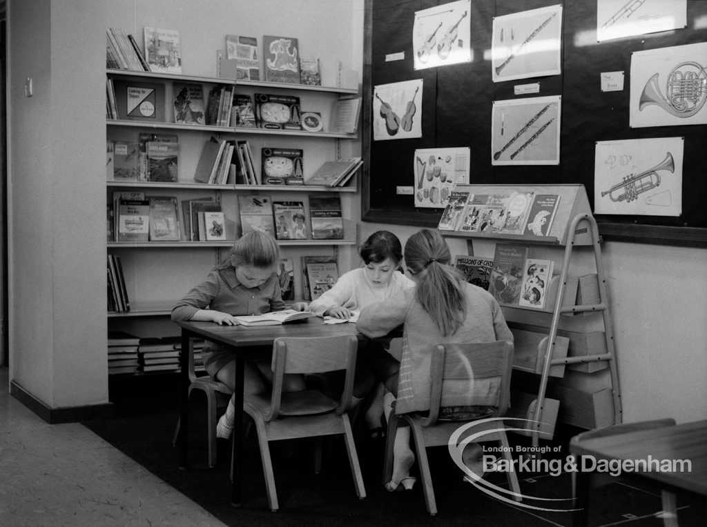 New William Bellamy Primary School, Becontree Heath, showing the library corner, with three girls seated around table and reading, 1970