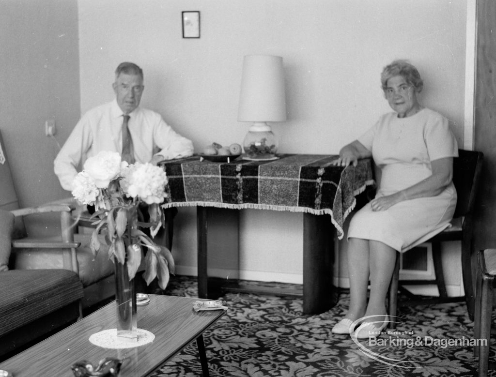 Housing at Grand Courts, Valence Wood Road, Dagenham, showing couple sitting either end of small table in lounge at flat, 1970