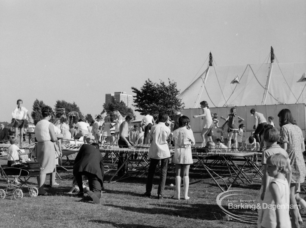 Dagenham Town Show 1970, showing trampolining children, parents and other visitors, with marquee in background, 1970