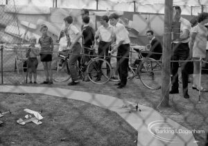 Dagenham Town Show 1970, showing model aeroplane flying, with cyclists and other visitors watching, 1970
