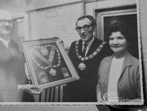 Photographic negative copy of old Valence House Museum photograph, showing press photograph of Barking and Dagenham Chamber of Trade and Industry President Mr Andrews and Mayor Vic Rusha displaying framed insignia in Museum Room, Valence House, Dagenham, 1970