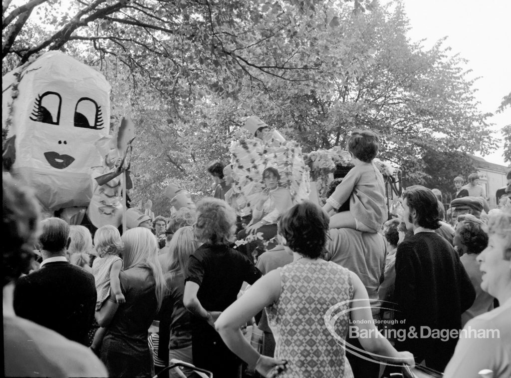 Barking Carnival 1970, showing spectators gathered around floats and  ‘big head’ masks, 1970