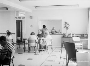 London Borough of Barking Welfare Department, Leys Training Centre Dagenham, showing dining room with serving hatch and people sitting around tables, 1971