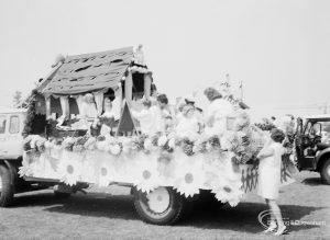 Dagenham Town Show 1971, showing rustic hut with large daisies around sides and mounted on carnival float, during judging in Old Dagenham Park, 1971