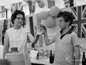 Dagenham Town Show 1971 at Central Park, Dagenham, showing Winemaking stand, with mother and son holding up a glass of wine, 1971