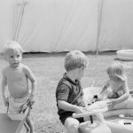 Dagenham Town Show 1971 at Central Park, Dagenham, showing three small children playing with toys outside a marquee, 1971