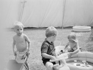 Dagenham Town Show 1971 at Central Park, Dagenham, showing three small children playing with toys outside a marquee, 1971