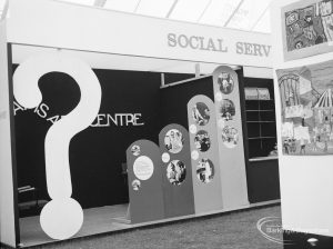 Dagenham Town Show 1971 at Central Park, Dagenham, showing the Social Services stand, featuring a large ‘?’ sign and photographs, 1971