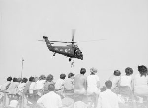 Dagenham Town Show 1971 at Central Park, Dagenham, showing demonstration of a Royal Navy helicopter rescuing a soldier, with spectators watching from below,1971
