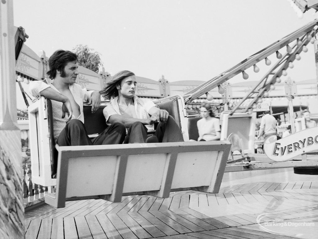 Dagenham Town Show 1971 at Central Park, Dagenham, showing two men on a fairground ride,1971