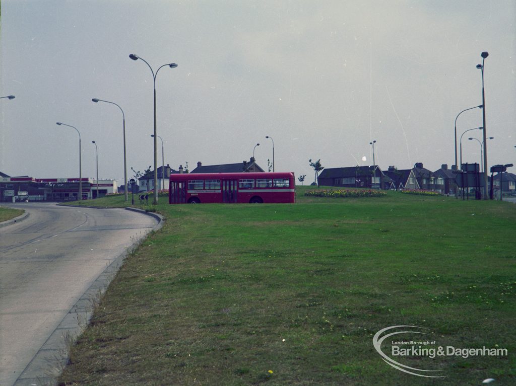 Britain in Bloom competition, showing roundabout at Ballards Road junction with Rainham Road South, Dagenham, distant view including red bus travelling north, 1971