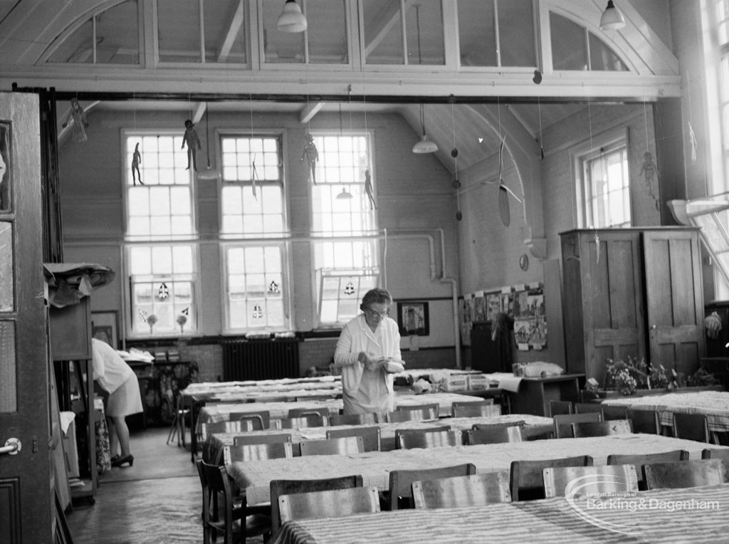Village Infants School, Church Elm Lane, Dagenham interior [closed 23 July 1971], showing women preparing tables for lunch, 1971