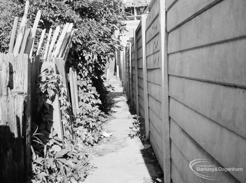 Footpath [to be closed] between Rectory Road and Vicarage Road, Dagenham, with concrete wall on right, 1971