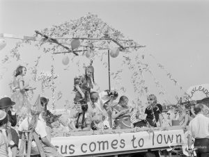 Assembly and departure of Barking Carnival 1971 from Mayesbrook Park, showing decorated float labelled ‘Jesus comes to Town’, 1971