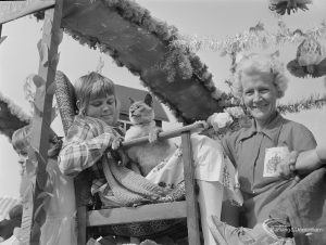 Barking Carnival 1971 from Mayesbrook Park, showing woman, children and cat on Domestic Harmony float, 1971
