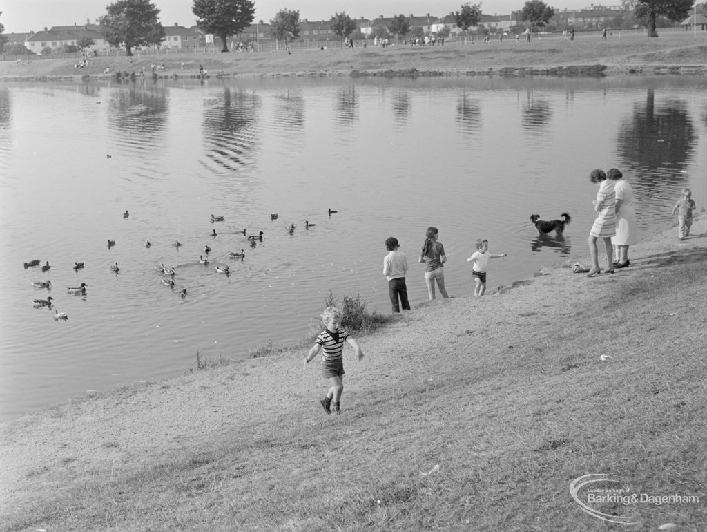 Barking Carnival 1971 from Mayesbrook Park, showing two women, group of children and dog by side of lake, with ducks in lake, 1971