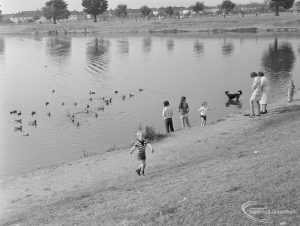 Barking Carnival 1971 from Mayesbrook Park, showing two women, group of children and dog by side of lake, with ducks in lake, 1971