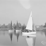 1c’ sailing boat passing before two red-sailed boats, at the Sailing Regatta in Mayesbrook Park, Dagenham, 1971