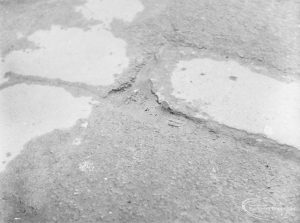 Highways, showing damaged tarmac paving at 72 High Road, Chadwell Heath, outside Old People’s Club (south side), 1972