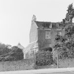 Site for Housing development at Paulatim Lodge, Chadwell Heath, taken after fire in roof and showing shuttered lean-to greenhouse on south side of Lodge, 1972