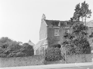 Site for Housing development at Paulatim Lodge, Chadwell Heath, taken after fire in roof and showing shuttered lean-to greenhouse on south side of Lodge, 1972