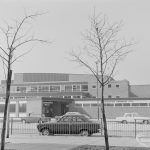 Dagenham Swimming Pool, Becontree Heath from north-east, framed between two bare spindly trees, 1972