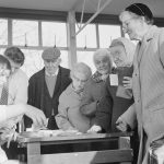 Woman in check coat, fla...