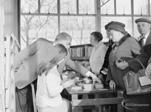 The visiting Superintendent sorting out a query as people wait for their bus permits in Children’s Library at Rectory Library, Dagenham, 1972