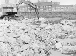 Borough Engineer’s Department clearance of site at Lindsell Road, Barking (Gascoigne 4, Stage 2), showing earth mover clearing dynamited concrete, 1972